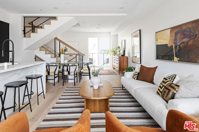 living room with sink and light hardwood / wood-style floors