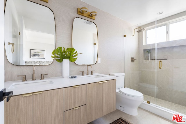 bathroom featuring tile patterned flooring, vanity, toilet, and a shower with door