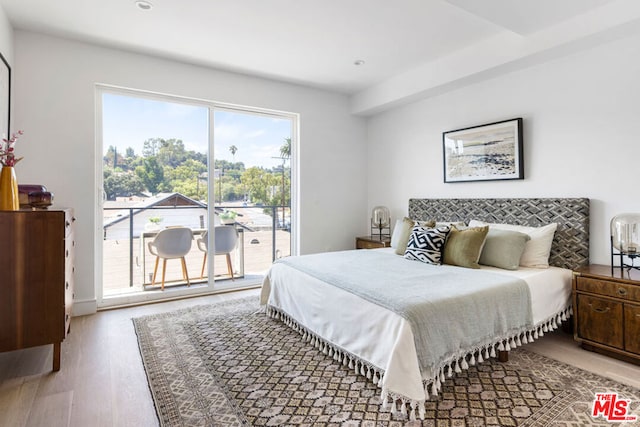 bedroom with access to exterior and hardwood / wood-style flooring