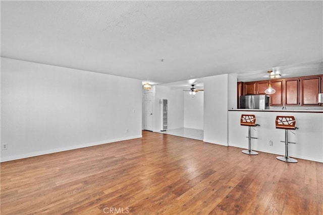 unfurnished living room featuring light hardwood / wood-style flooring and ceiling fan