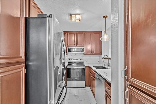 kitchen featuring decorative light fixtures, stainless steel appliances, and sink