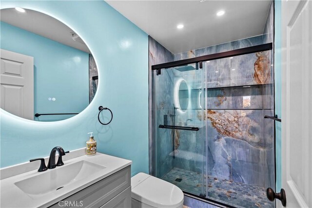 bathroom with vanity, an enclosed shower, and toilet