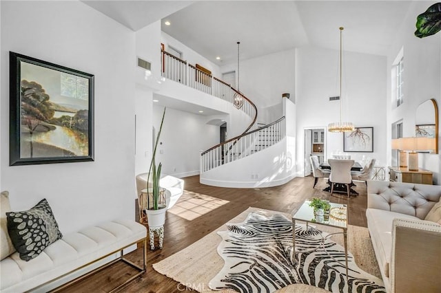 living room featuring an inviting chandelier, dark hardwood / wood-style floors, and high vaulted ceiling