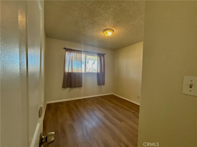 unfurnished room featuring a textured ceiling and hardwood / wood-style flooring