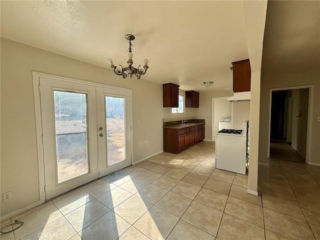 kitchen featuring light tile patterned floors, ventilation hood, an inviting chandelier, and white gas range