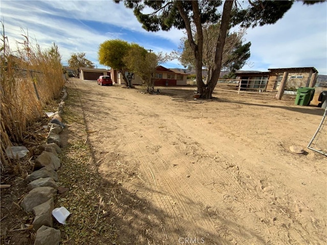 view of yard with a garage and an outbuilding