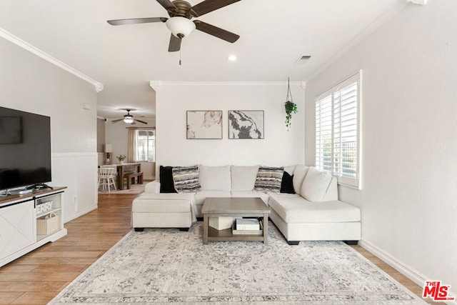 living room featuring hardwood / wood-style floors, ceiling fan, and ornamental molding