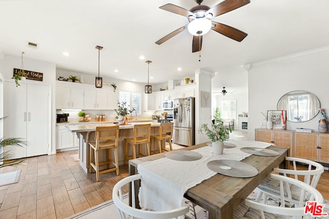 dining room featuring ceiling fan, crown molding, and light hardwood / wood-style flooring