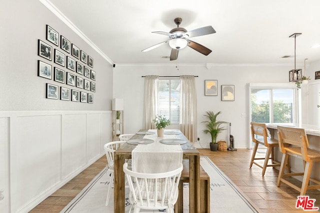 dining room with a wealth of natural light, crown molding, ceiling fan, and light wood-type flooring