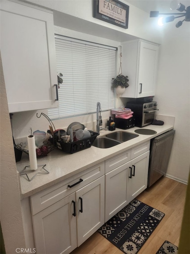 kitchen featuring white cabinetry, sink, dishwasher, and light hardwood / wood-style floors