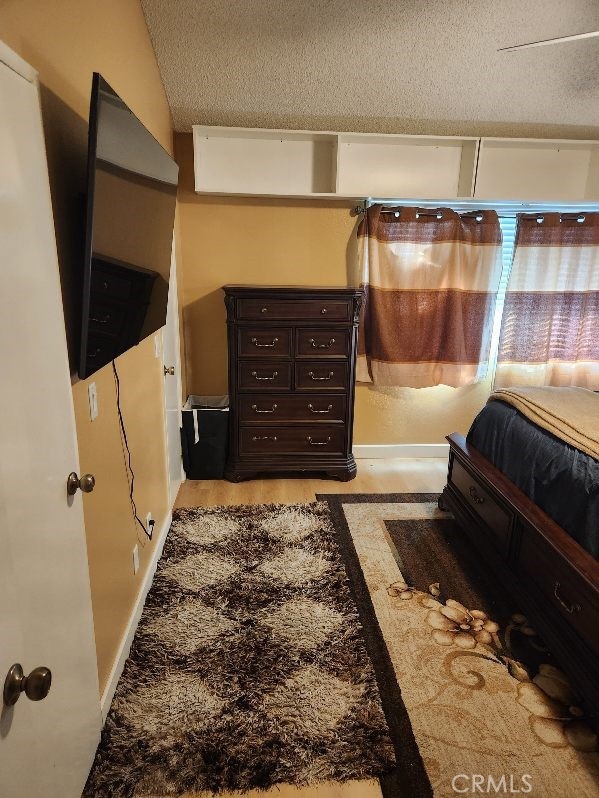 bedroom with lofted ceiling and a textured ceiling