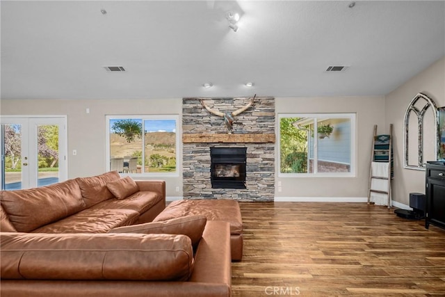 living room featuring a fireplace, wood-type flooring, and french doors