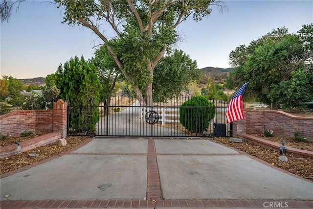 gate at dusk featuring a mountain view