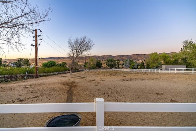 yard at dusk featuring a mountain view