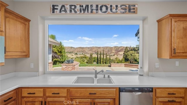 kitchen with a mountain view, stainless steel dishwasher, a wealth of natural light, and sink