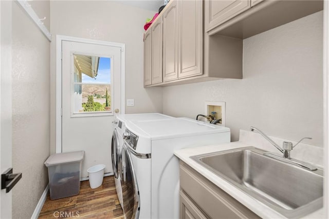 laundry room featuring cabinets, independent washer and dryer, dark hardwood / wood-style flooring, and sink