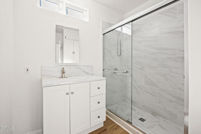 bathroom with hardwood / wood-style floors, vanity, and walk in shower