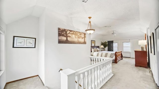 bedroom featuring a textured ceiling, a crib, light carpet, and vaulted ceiling