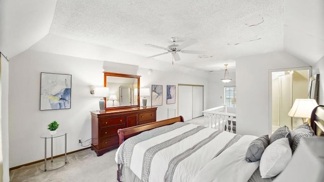 carpeted bedroom featuring a textured ceiling, a closet, ceiling fan, and lofted ceiling