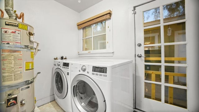 clothes washing area with a wealth of natural light, strapped water heater, and washing machine and dryer