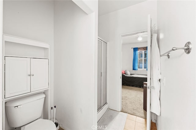 bathroom with tile patterned flooring, an enclosed shower, and toilet