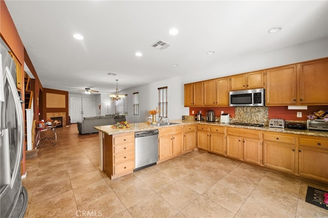 24809 Melrose Dr, Menifee, CA 92585 - kitchen with tasteful backsplash, appliances with stainless steel finishes, visible vents, open floor plan, and a peninsula