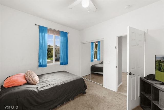 bedroom featuring light carpet, a closet, and ceiling fan