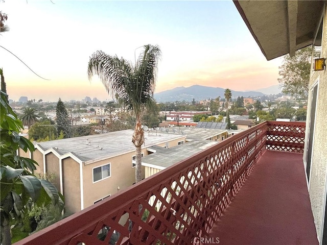 balcony at dusk featuring a mountain view