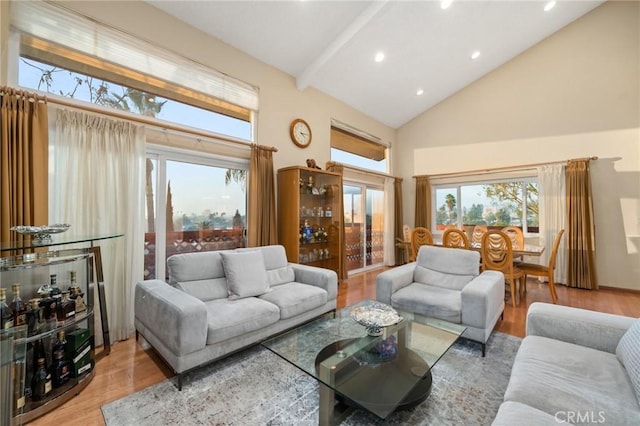 living room with hardwood / wood-style floors, high vaulted ceiling, and beam ceiling