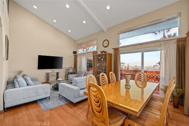 dining room with beamed ceiling, high vaulted ceiling, and light hardwood / wood-style floors