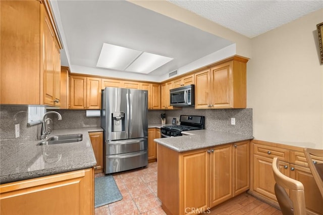 kitchen featuring appliances with stainless steel finishes, tasteful backsplash, sink, light tile patterned floors, and stone countertops