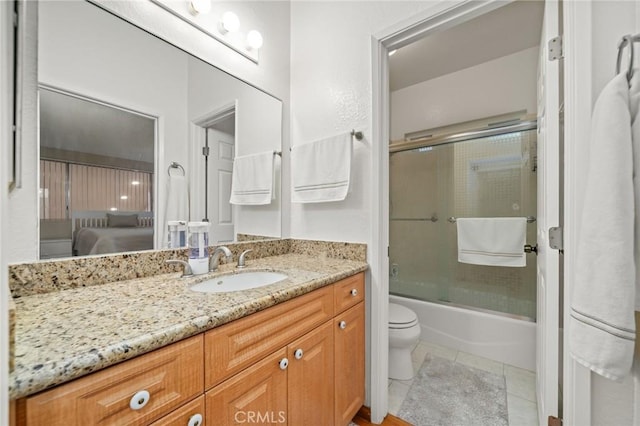 full bathroom featuring tile patterned floors, vanity, enclosed tub / shower combo, and toilet