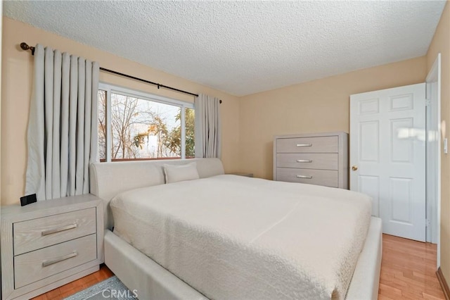 bedroom featuring light wood-type flooring and a textured ceiling