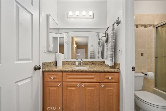 full bathroom featuring shower / bath combination with glass door, vanity, and toilet