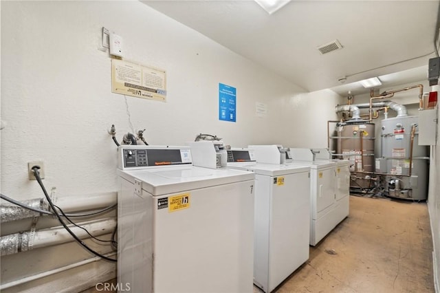 washroom with washing machine and dryer and water heater