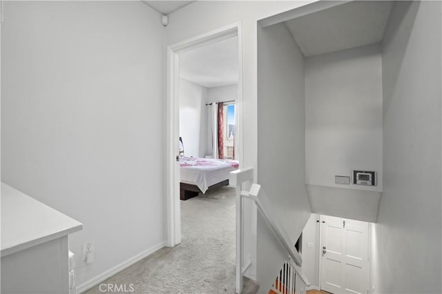 hallway featuring light colored carpet