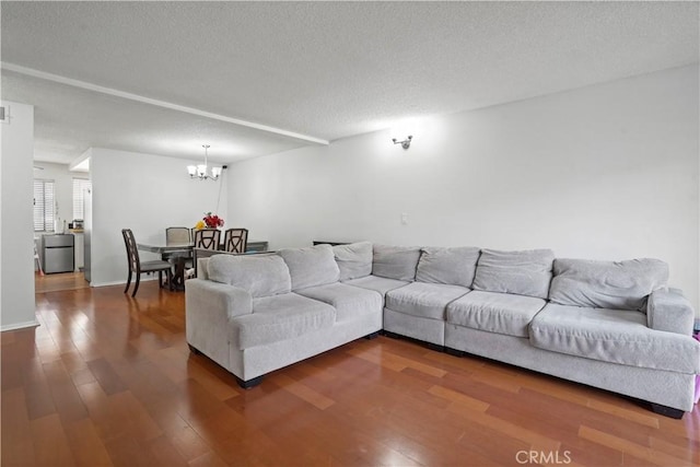 living room featuring a chandelier, wood-type flooring, and a textured ceiling