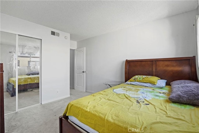 carpeted bedroom with a textured ceiling and a closet