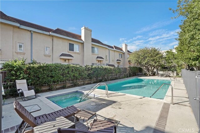 view of swimming pool featuring a patio area and a community hot tub