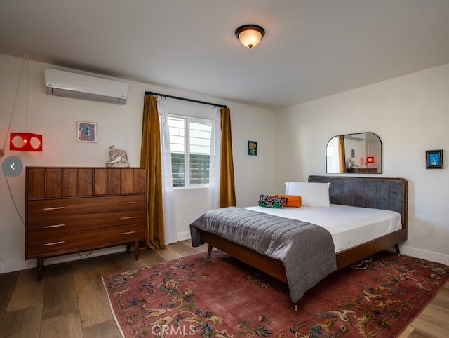 bedroom featuring wood-type flooring and a wall mounted AC