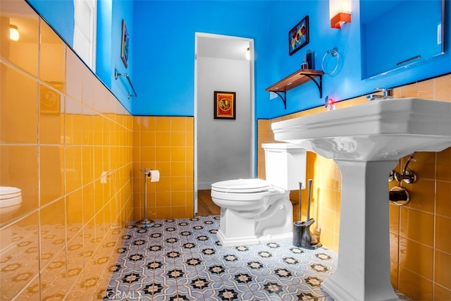 bathroom with toilet and tile walls