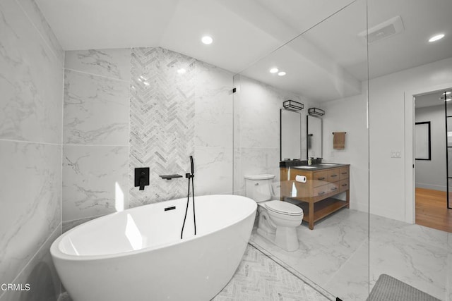 bathroom with vanity, vaulted ceiling, a bath, tile walls, and toilet