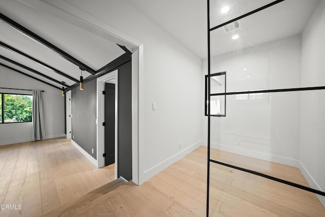 interior space with lofted ceiling with beams and light hardwood / wood-style flooring