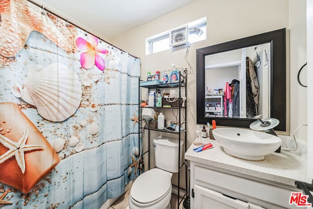 bathroom featuring vanity, toilet, and curtained shower