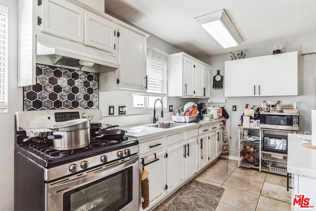 kitchen with sink, white cabinetry, stainless steel appliances, and light tile patterned floors