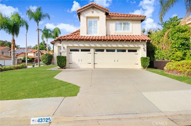 mediterranean / spanish house featuring a front yard and a garage