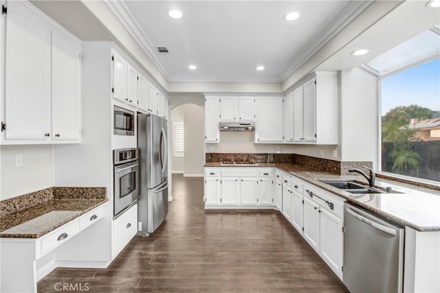 kitchen featuring white cabinets, crown molding, sink, appliances with stainless steel finishes, and dark hardwood / wood-style flooring