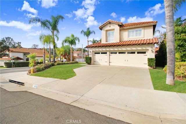 mediterranean / spanish home with a garage and a front lawn