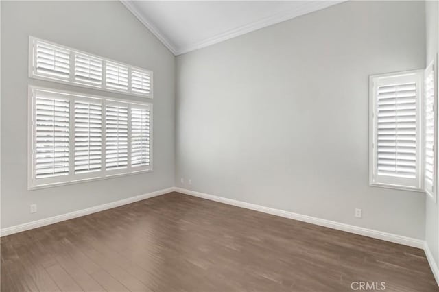 spare room with dark hardwood / wood-style floors, crown molding, and vaulted ceiling