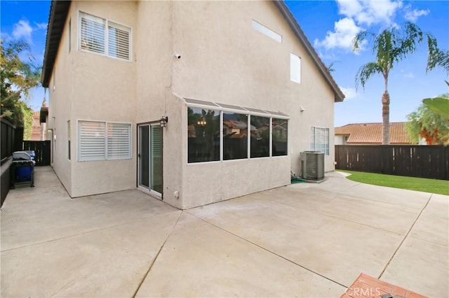 rear view of property with cooling unit and a patio area